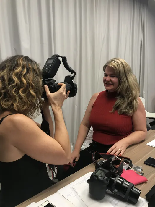 Aluna praticando fotografia odontológica com câmera e flash