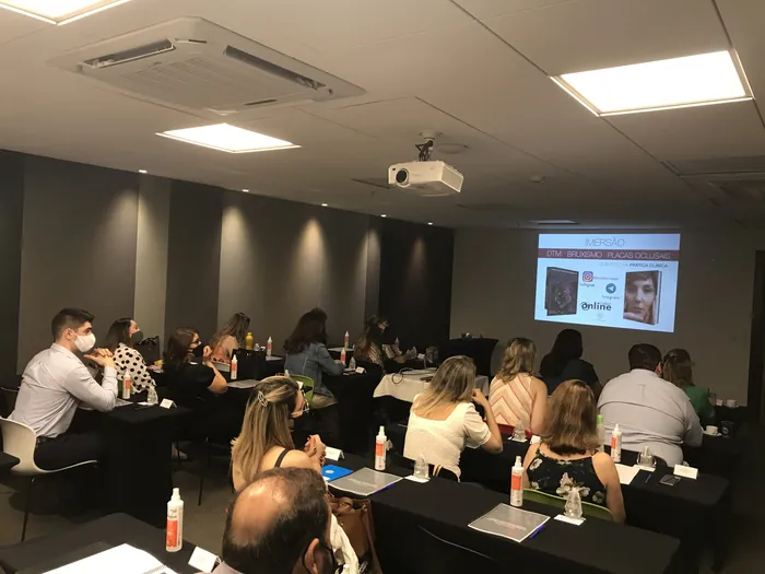 Turma em sala de aula acompanhando slide com caso clínico